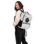 Smiling woman wearing white patterned backpack