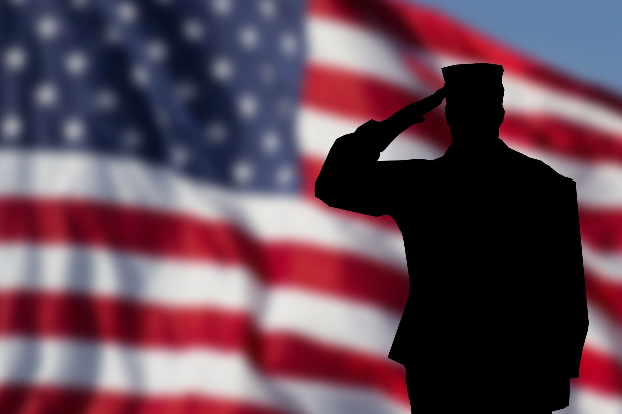 Silhouette of soldier saluting before American flag