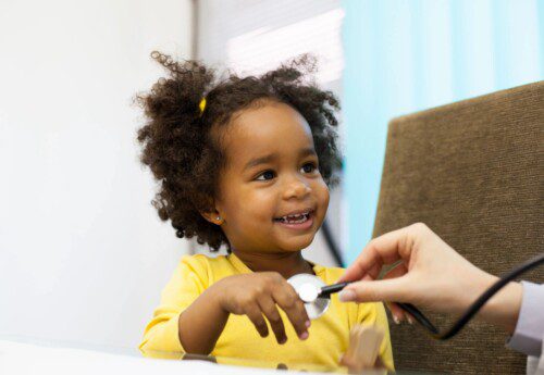 Smiling toddler during playful stethoscope checkup
