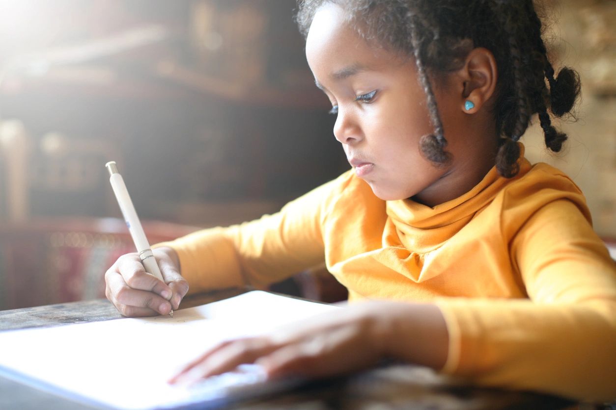 Young girl focused writing in notebook