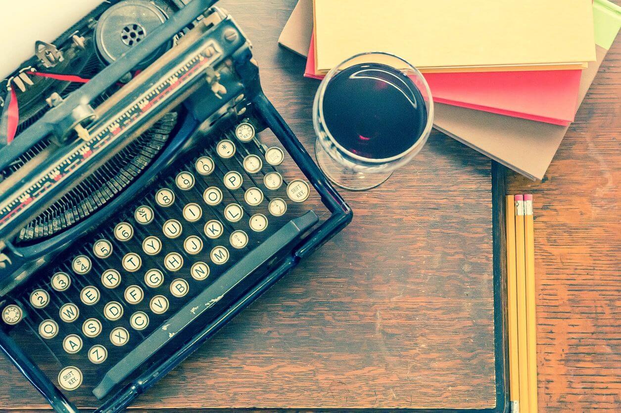 Vintage typewriter with coffee, notebooks, pencils